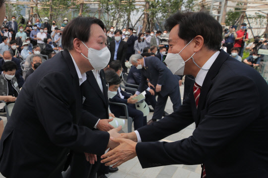 오세훈 서울시장(오른쪽)이 9일 오후 열린 서울 남산예장공원 개장식 겸 우당 이회영 선생 기념관 개관식에 참석한 윤석열 전 검찰총장(왼쪽)과 악수하고 있다.연합뉴스